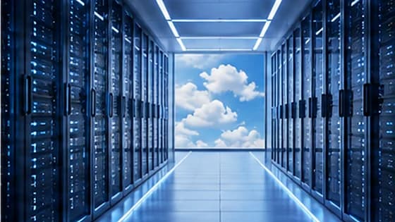 Data centre corridor between lit racks opening directly onto blue sky and cloud